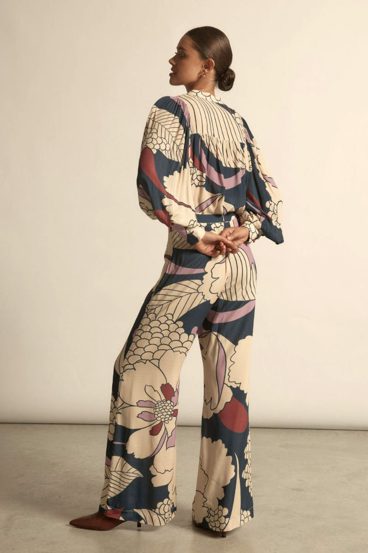 Woman wearing petals print with purple, red and blue accents matching with wide leg printed in soft, flowing fabric.