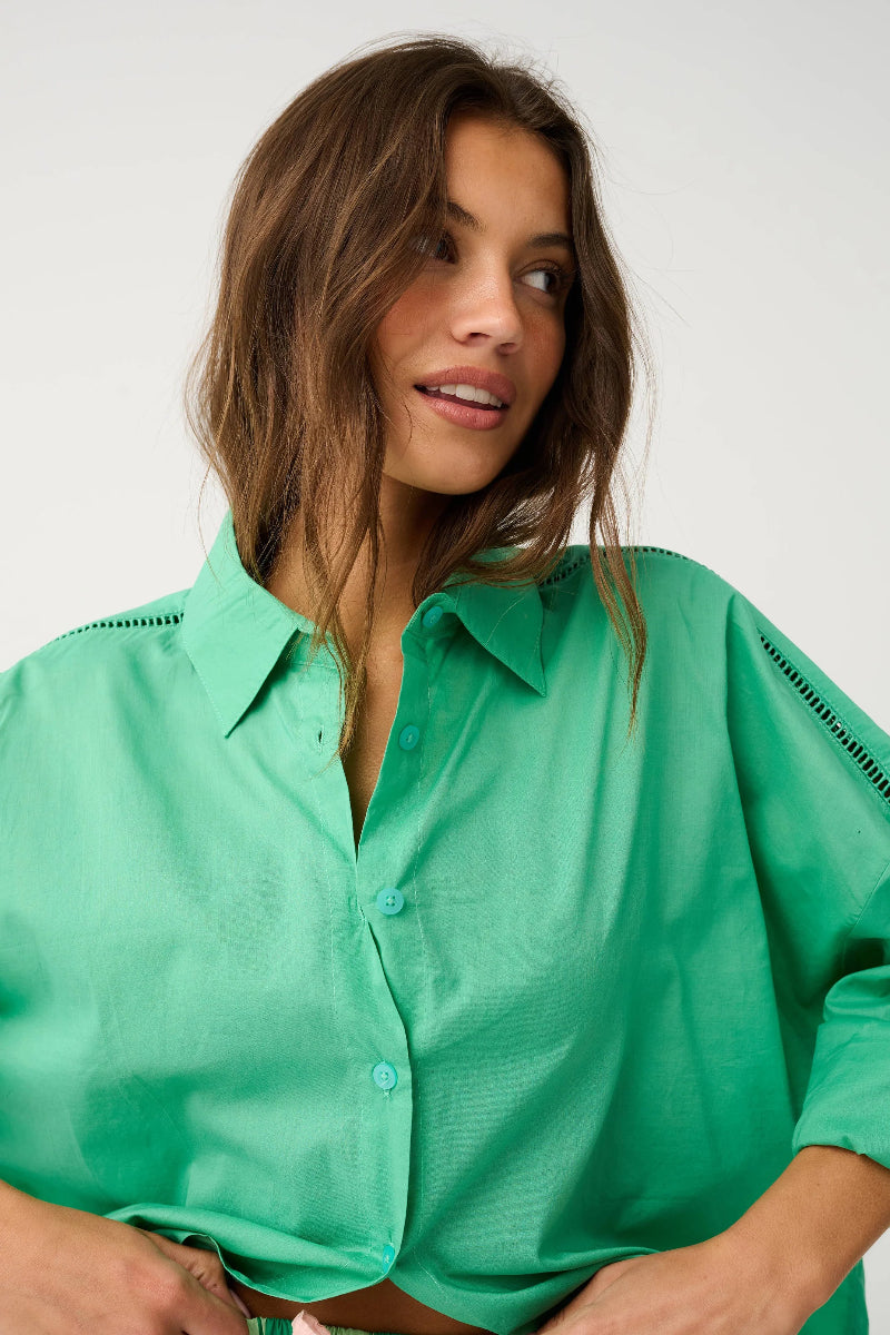Close-up of green collared button-up shirt detail.