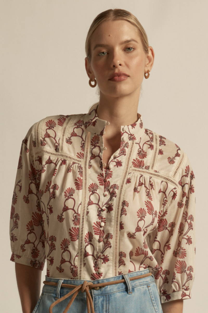 Woman wearing a floral blouse with a neutral background
