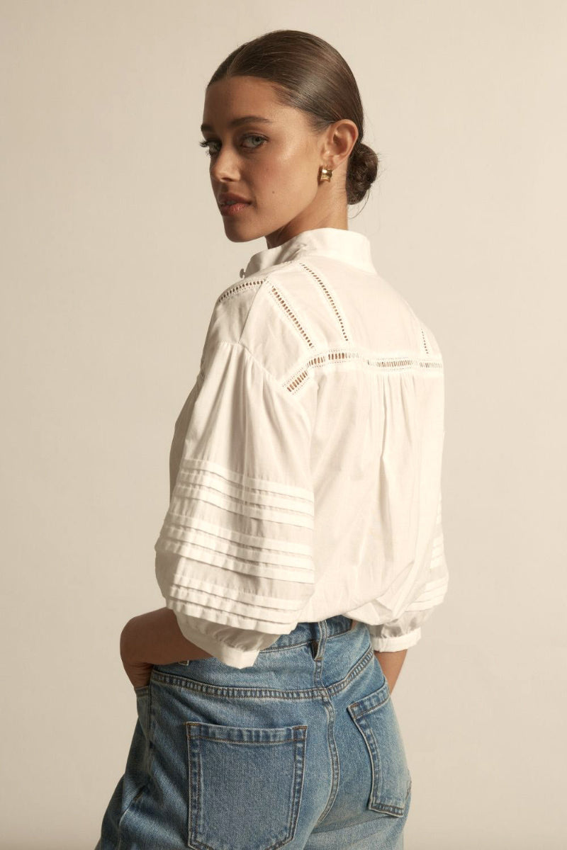White textured blouse with short puff sleeves, delicate lace trim panels.