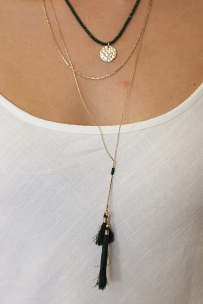 halo layered necklace on gold chains with forest green tones, tassels and beads